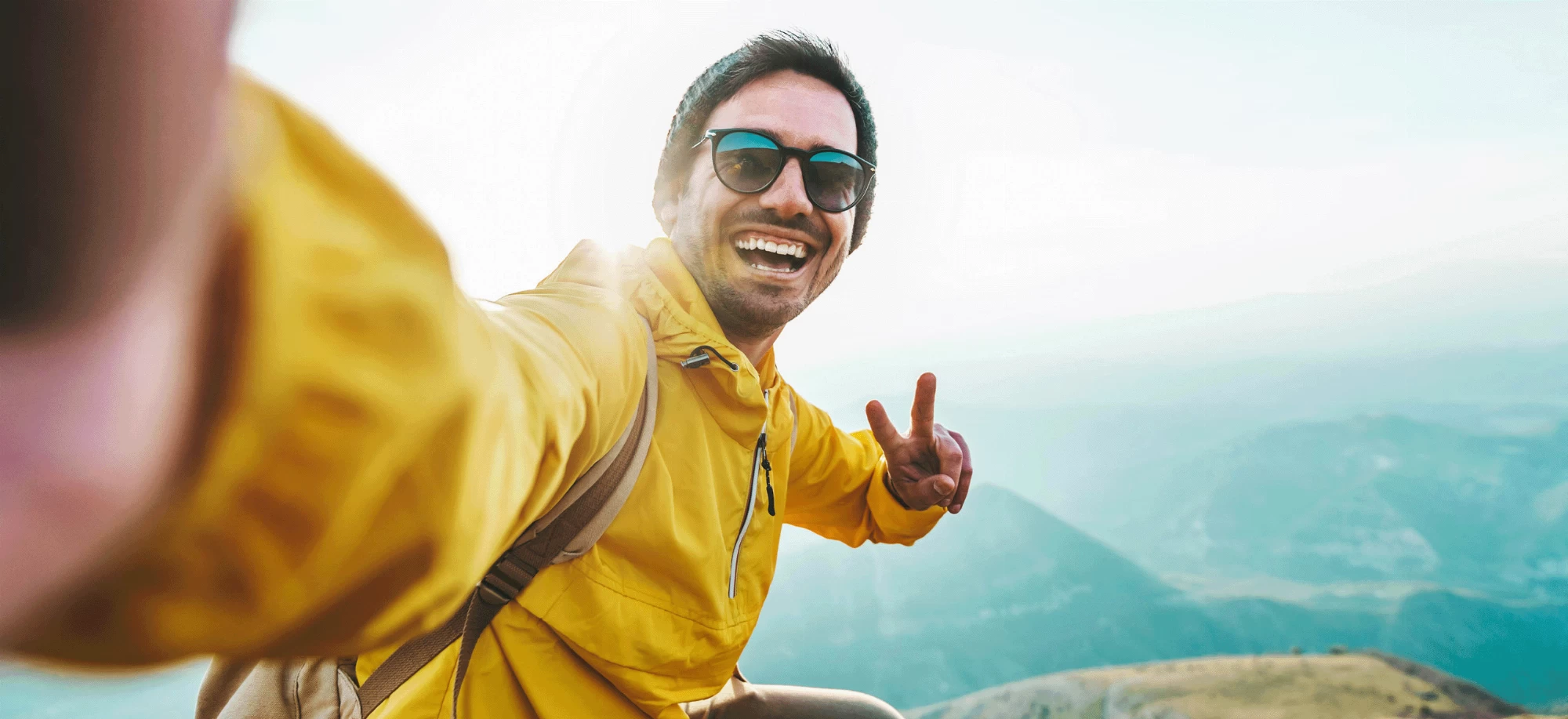 Image of a happy man on top of a mountain